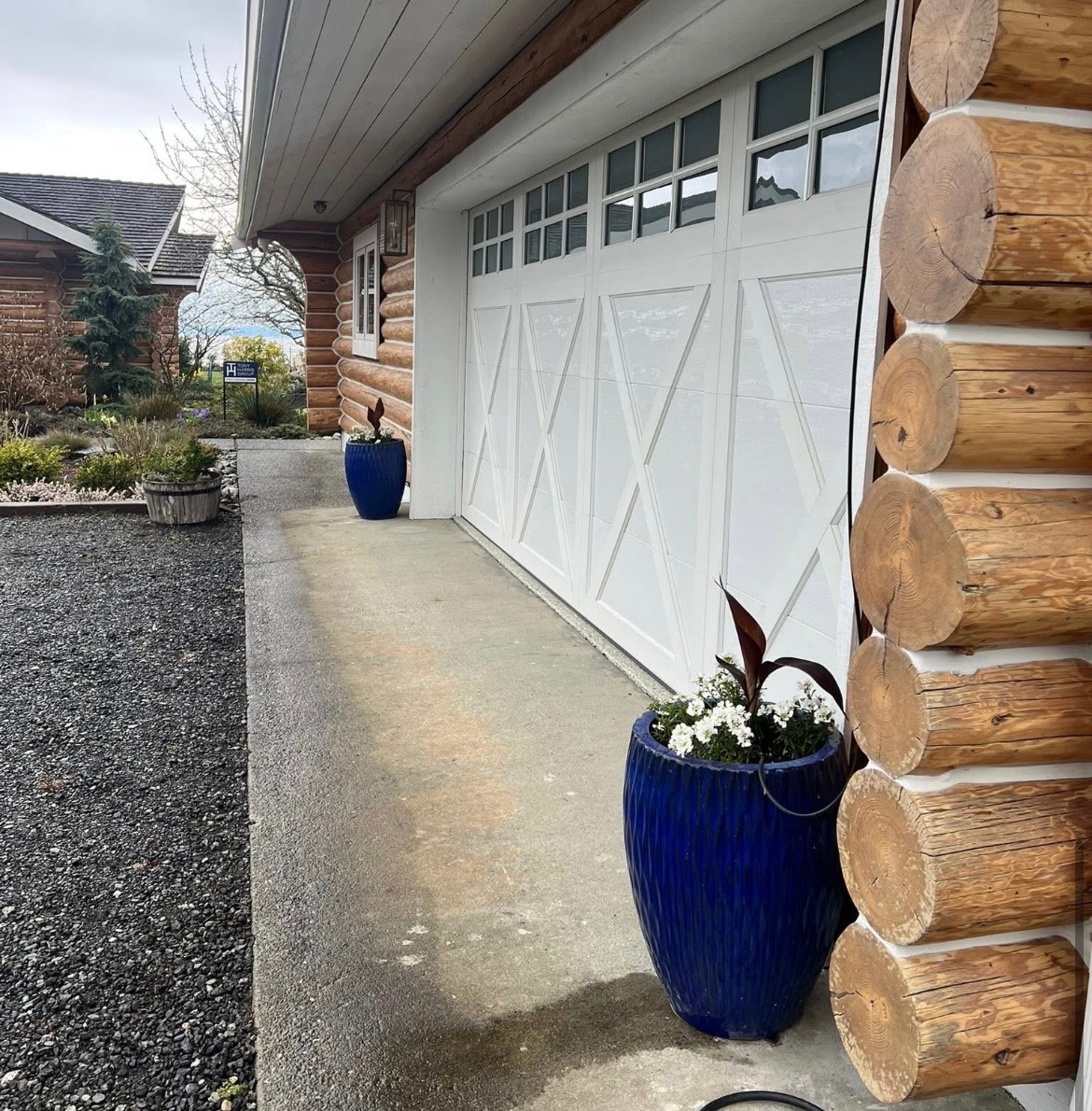 Pair of cobalt-blue ceramic urns flanking a log home garage entry in Nanaimo
