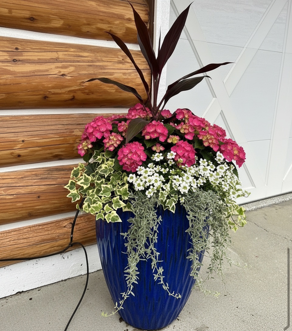 Premium cobalt-blue urn planter with a lush summer arrangement at a log home